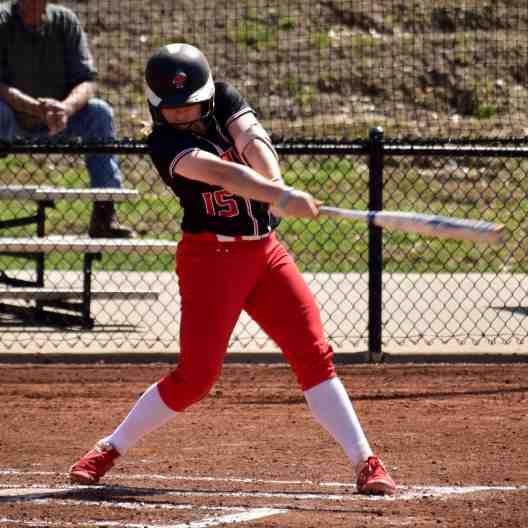 Softball player swinging at a pitch