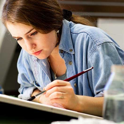 A student at a drafting table in Architecture class